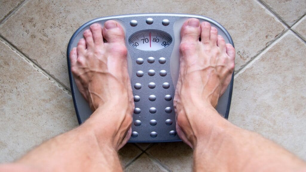 A man checking if he has a healthy weight for a 5'10 male