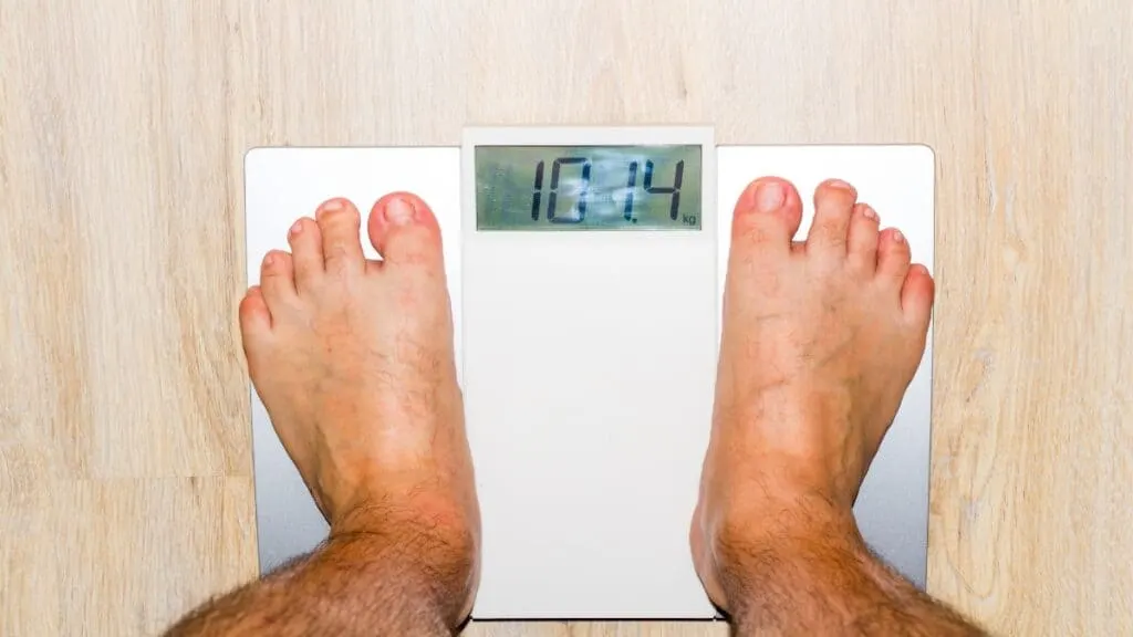 A man showing that he has the ideal weight for a 6'1 male